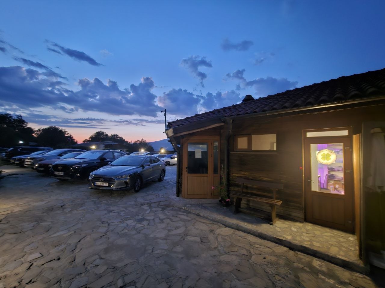 FLC Kitchen from outside at dusk, illuminated window sign